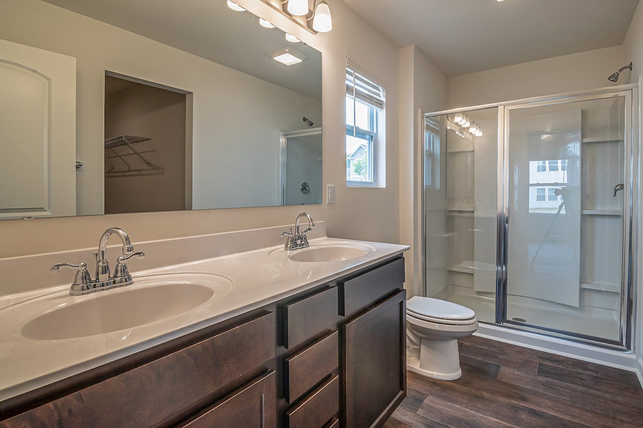 creative Spacious bathroom with dual sinks, glass shower, and contemporary design.